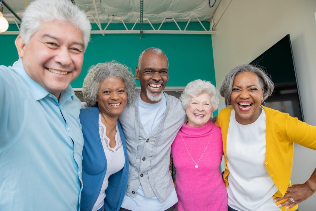 five adults smiling for a selfie