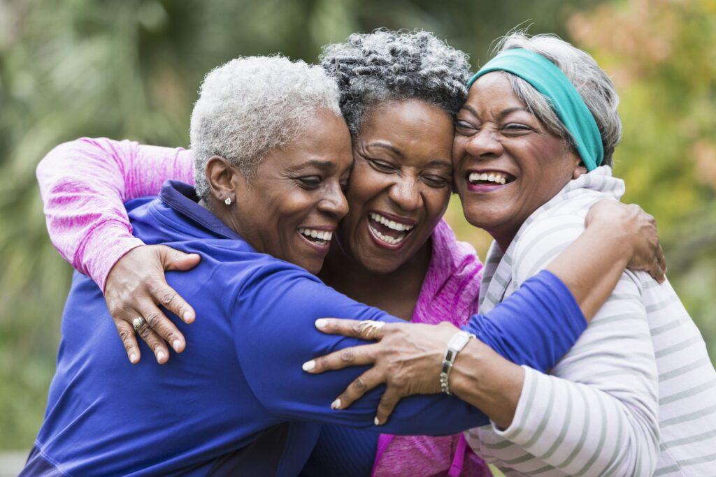 three women hugging and smiling