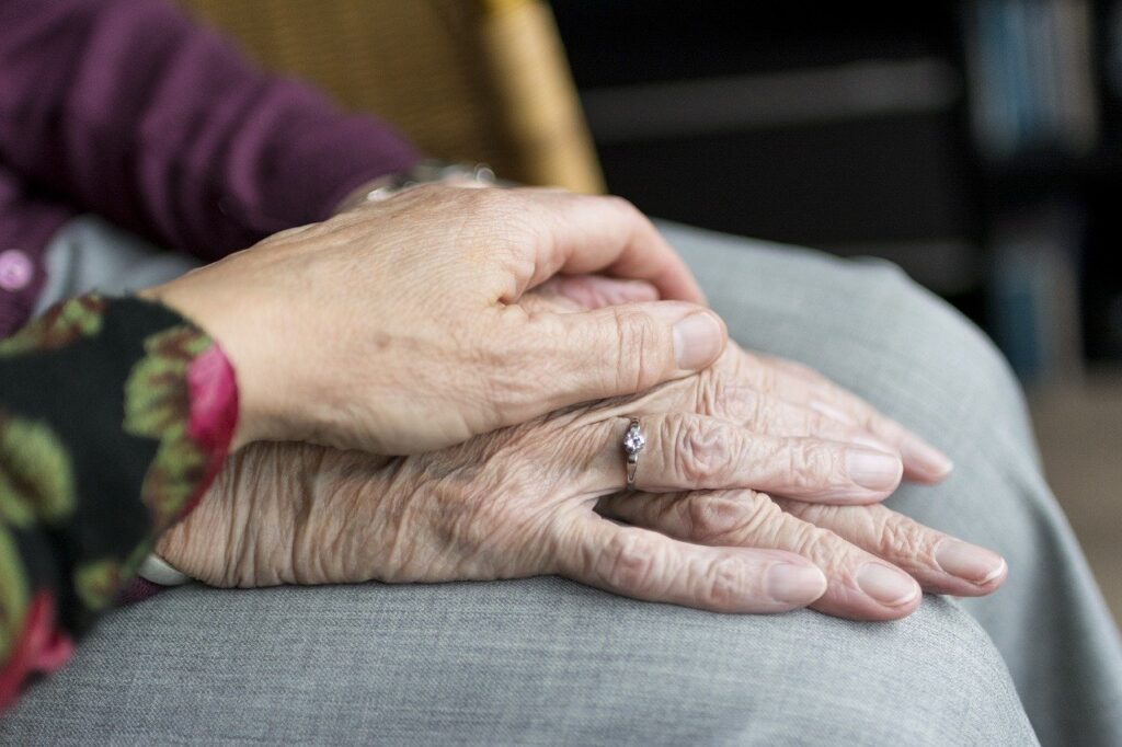 an elderly couple holding hands