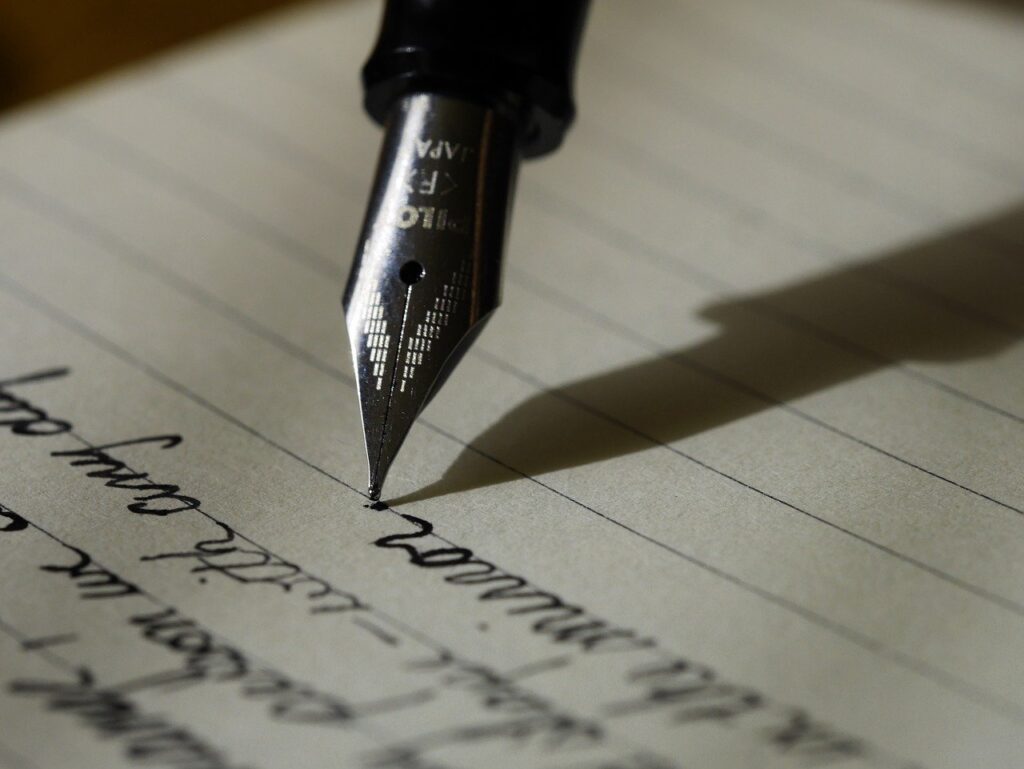 a pen writing in cursive
